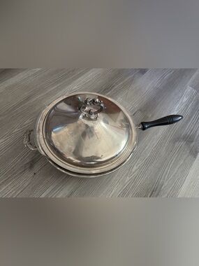 Pyrex glass insert inside a covered silver-plated pot with lid. Used